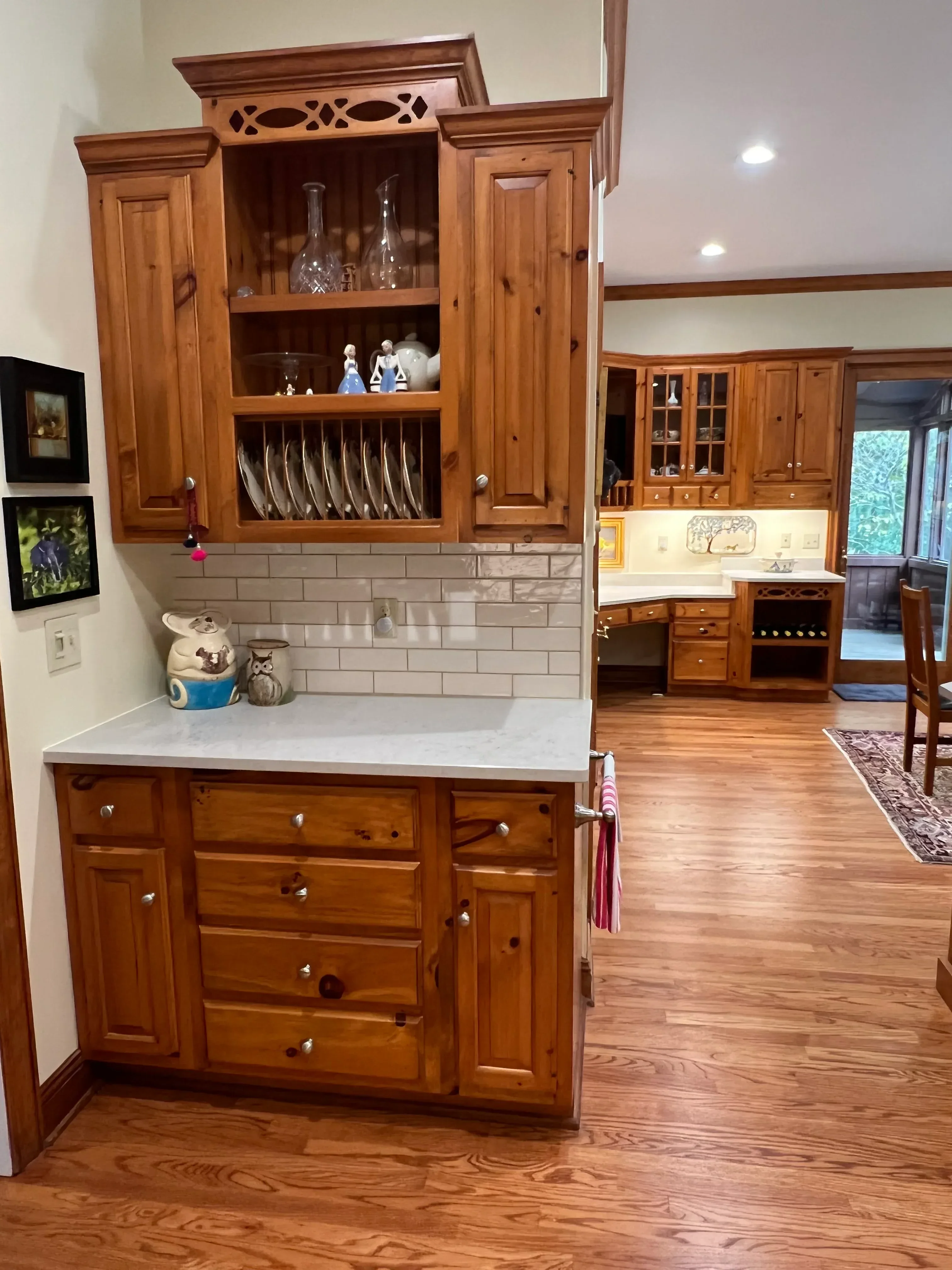 Custom knotty pine kitchen cabinets with glass doors, drawers, and subway tile backsplash