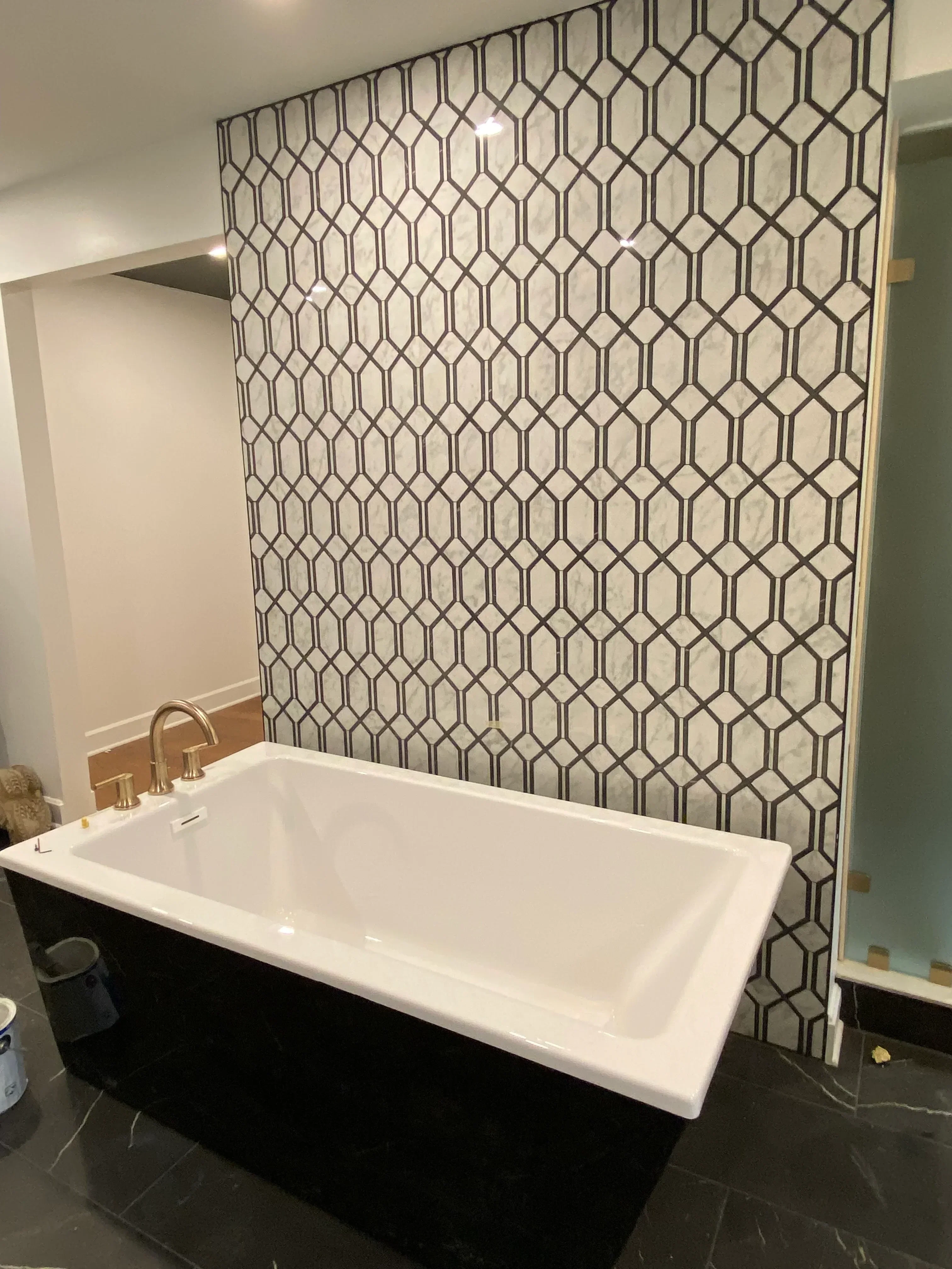 Hexagonal geometric tile floor with dark grout pattern and white vanity installation