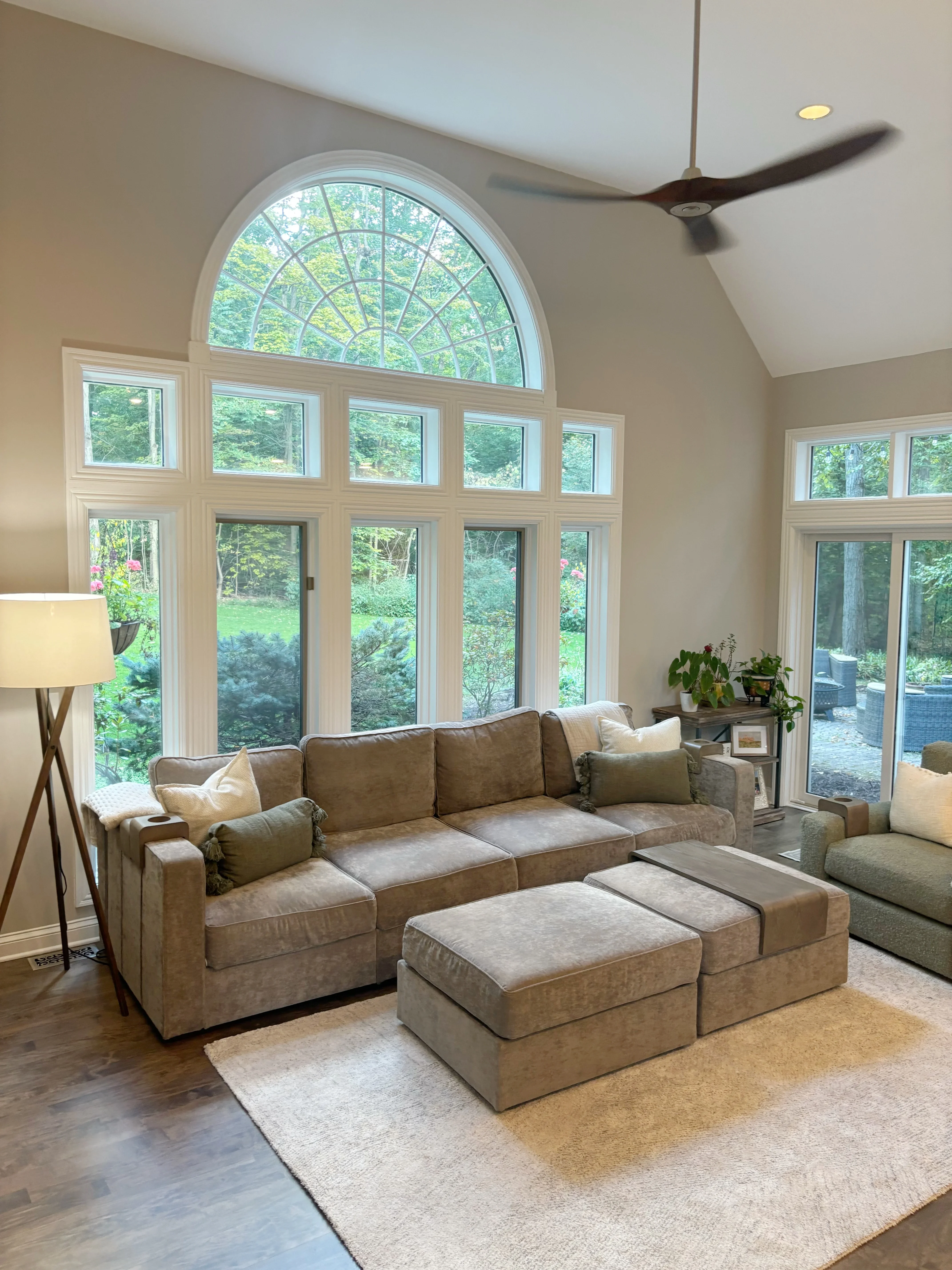 Sunroom with multi-pane casement windows, arched transom, hardwood floors, and ceiling fan