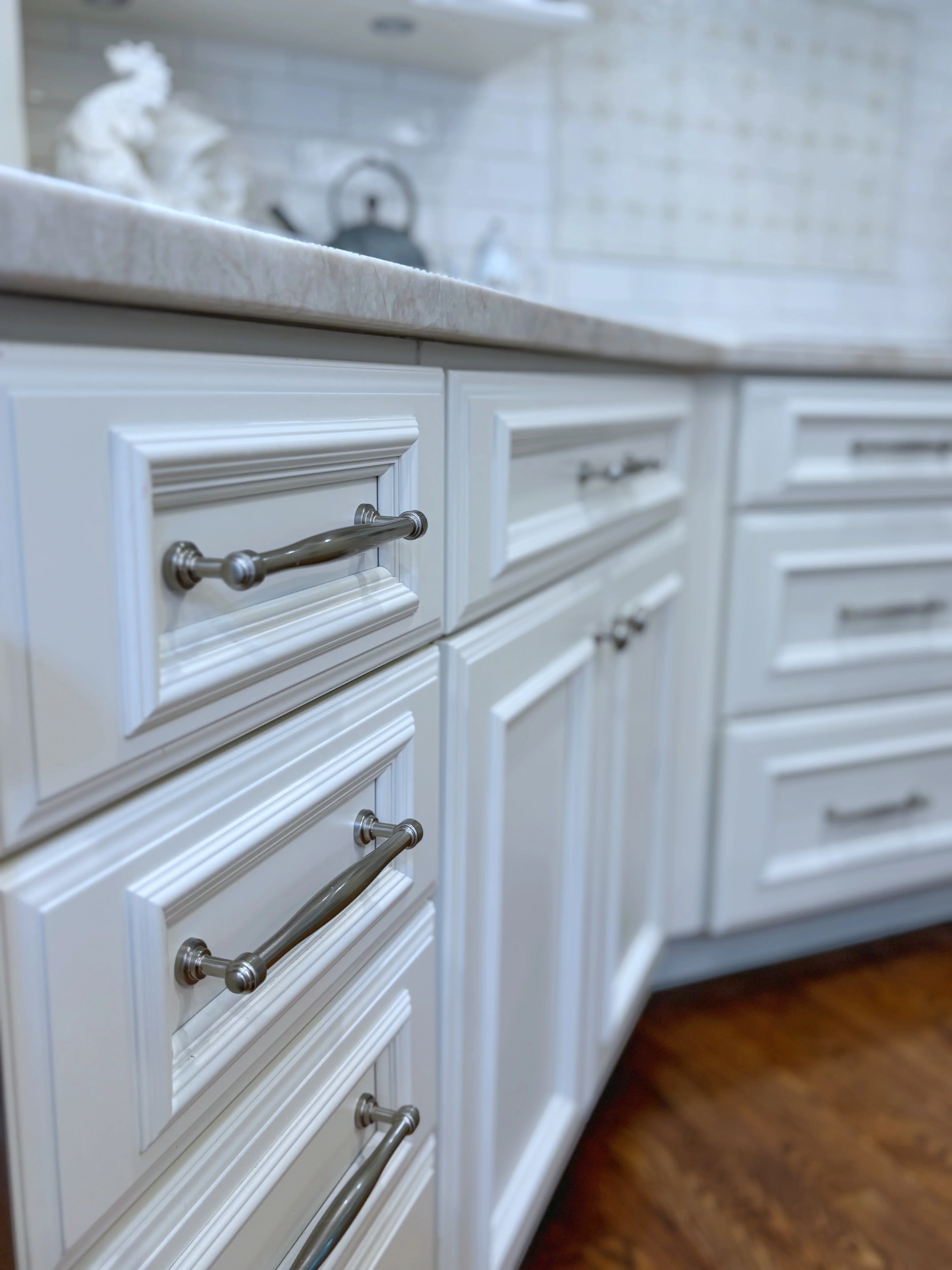 White shaker cabinets with brushed nickel hardware and gray quartz countertop
