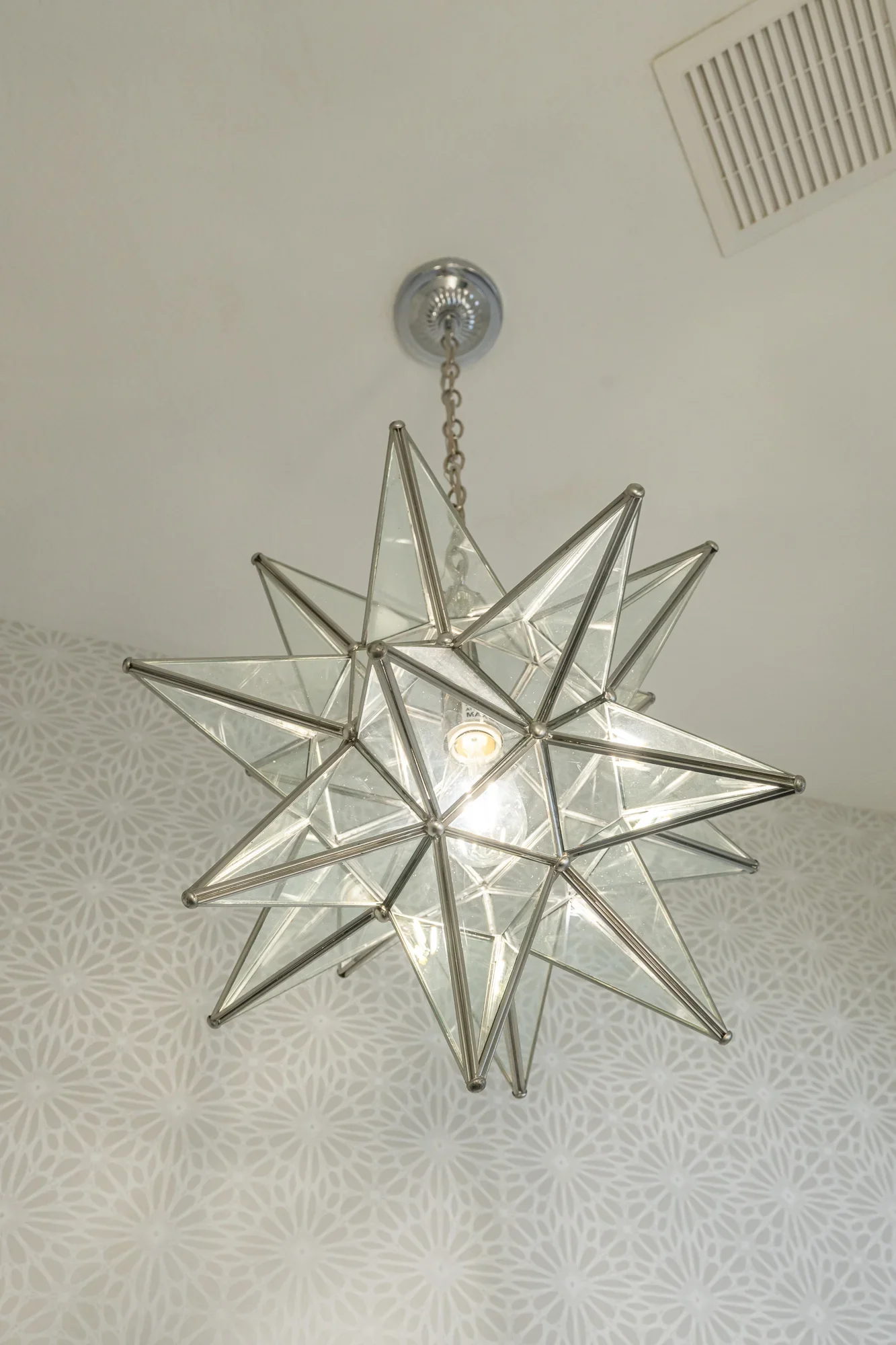 Polished nickel geometric star pendant light with clear glass panels and chain suspension